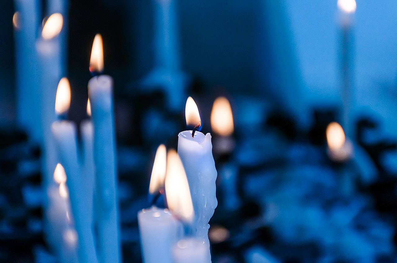 white candles in a room with a bluish hue